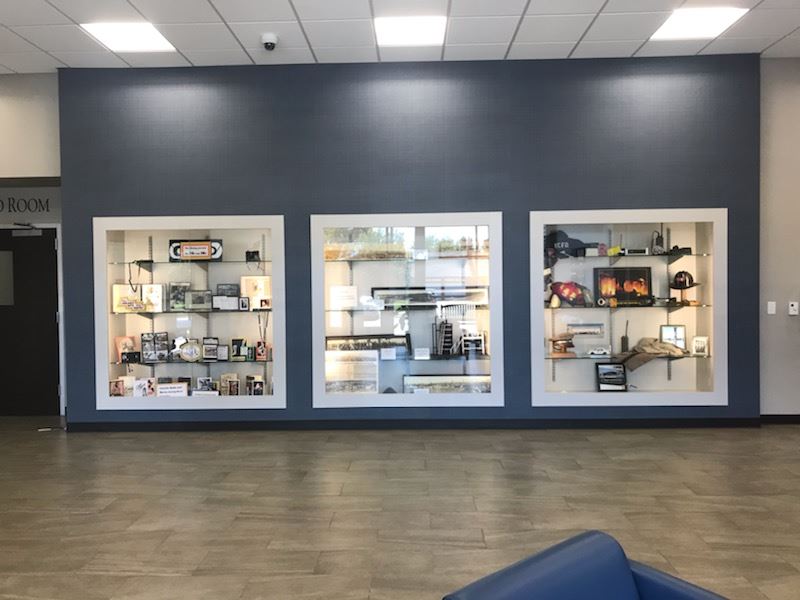 large room showcasing a blue couch and a shelf-filled wall